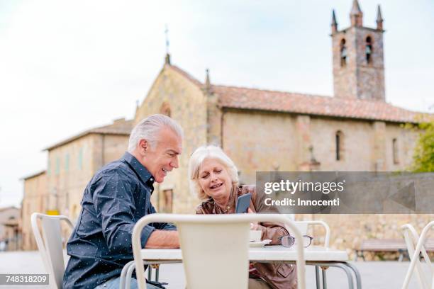 tourist couple looking at smartphone at sidewalk cafe, siena, tuscany, italy - good news stock pictures, royalty-free photos & images