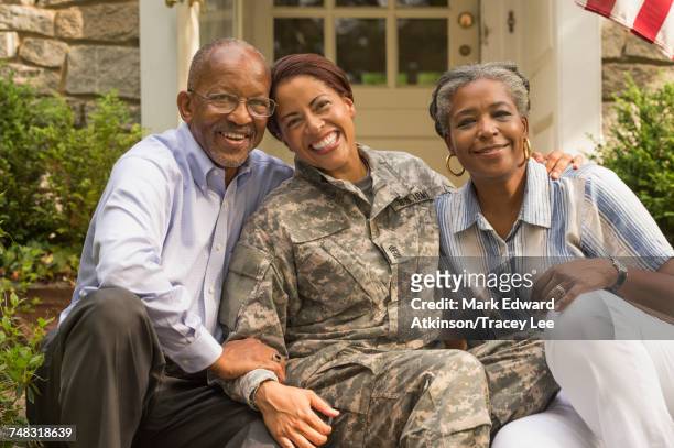 portrait of soldier sitting on front stoop with parents - american indian military stock pictures, royalty-free photos & images
