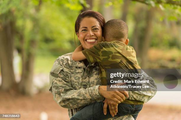 african american soldier mother carrying and hugging son - military uniform stock pictures, royalty-free photos & images