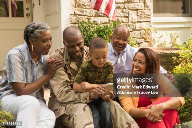 soldier and multi-generation family looking down at cell phone - american indian military stock pictures, royalty-free photos & images