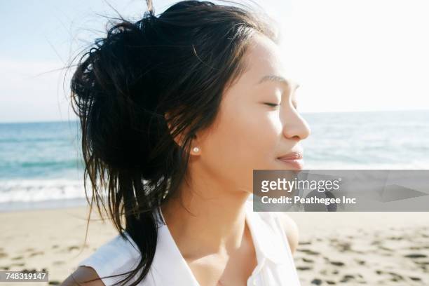 portrait of vietnamese woman at beach with eyes closed - hot vietnamese women stock pictures, royalty-free photos & images