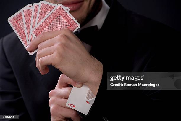 man holding playing cards, ace in sleeve - ass stock-fotos und bilder
