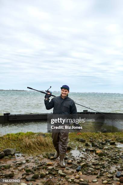 portrait of young male sea fisher with fishing rod over his shoulder - kway photos et images de collection