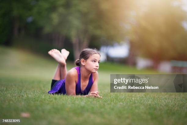 girl lying on front on grass - farbharmonie stock-fotos und bilder