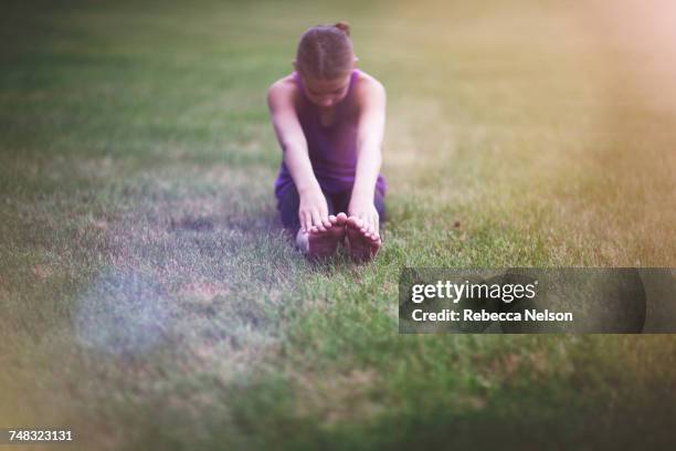 girl stretching on grass - farbharmonie stock-fotos und bilder