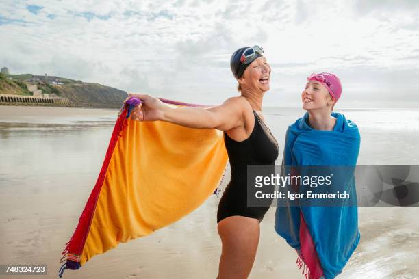 mother and daughter standing on beach with shawls, folkestone, uk - mature woman daughter stock pictures, royalty-free photos & images