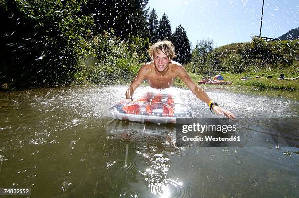 teenage boy (16-17) jumping on air bed - sólo-una-adolescente fotografías e imágenes de stock