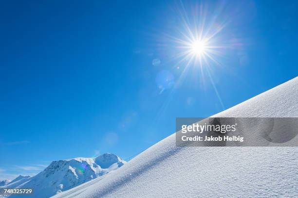 snow-covered hillside with sun shining, hintertux, tirol, austria - snow hill stock pictures, royalty-free photos & images
