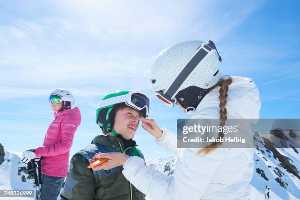 mother putting sunscreen on son, hintertux, tirol, austria - family winter sport stock pictures, royalty-free photos & images