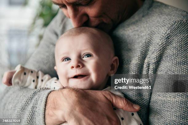 mature father kissing laughing baby on its head - 4 months stock pictures, royalty-free photos & images