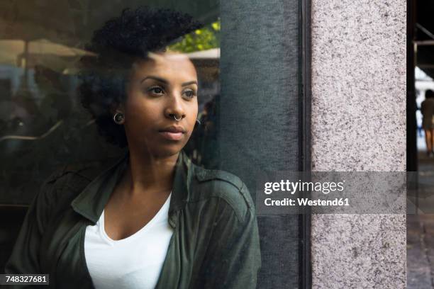 portrait of young woman looking out a window in a cafe - black woman looking at view stock pictures, royalty-free photos & images