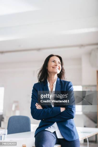 portrait of smiling businesswoman in a loft - blue blazer stock pictures, royalty-free photos & images