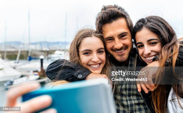 three friends taking a selfie at the marina - passagier wasserfahrzeug stock-fotos und bilder