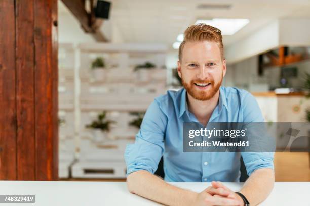 businessman in office sitting at desk - red head man fotografías e imágenes de stock