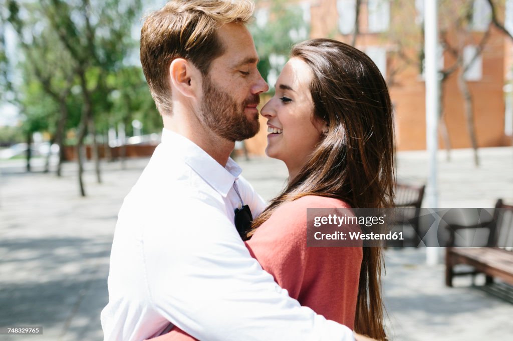 Happy couple kissing and hugging in the street