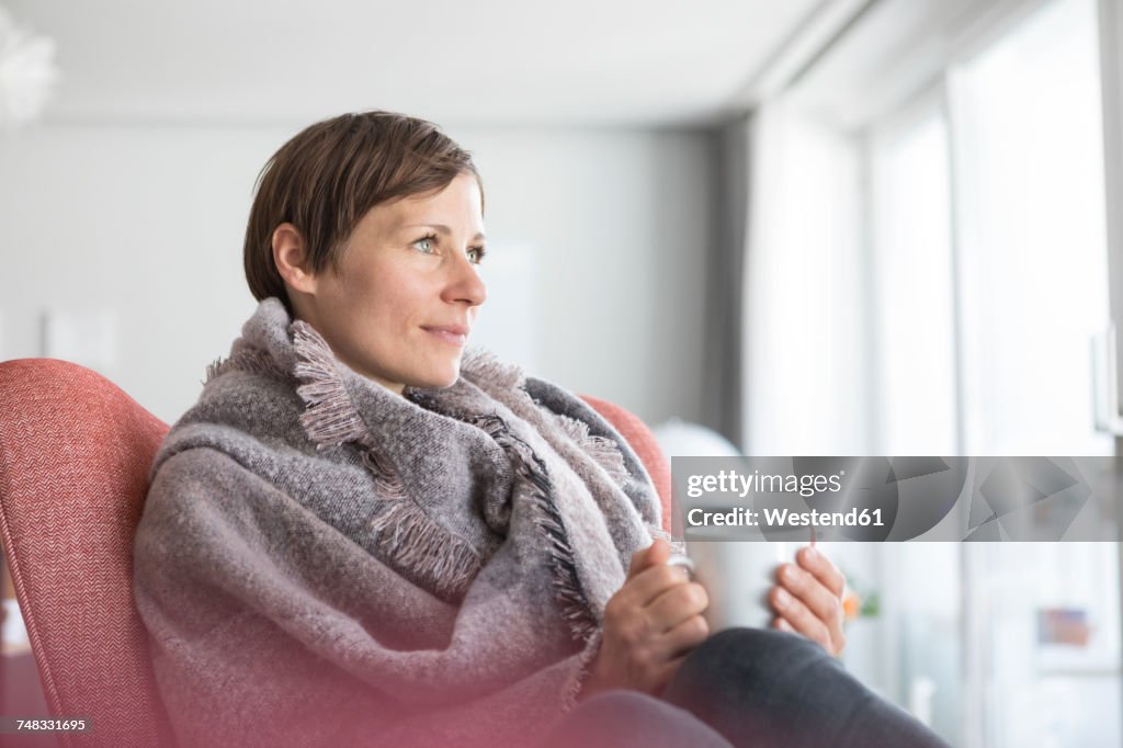 Portrait of woman relaxing with cup of coffee at home