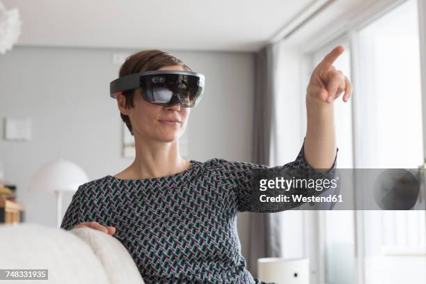 woman at home using augmented reality glasses at home - smart glasses stock pictures, royalty-free photos & images