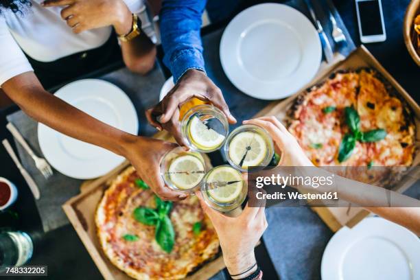 group of friends having pizza and clinking glasses of water at home - dining overlooking water stockfoto's en -beelden