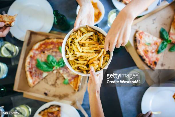 hand taking french fries from bowl - take out food stock pictures, royalty-free photos & images