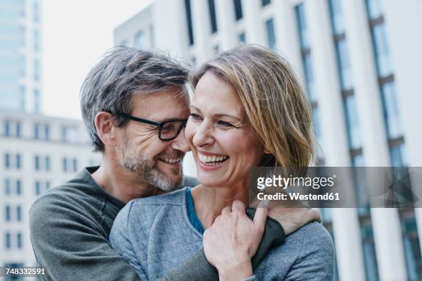 happy mature couple hugging outdoors - frau zwischen 50 und 60 stock-fotos und bilder