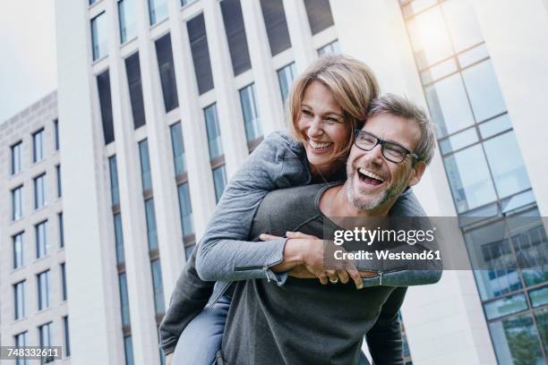 carefree mature couple outdoors - piggy back stockfoto's en -beelden