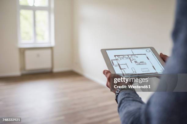 man in new home holding tablet with floor plan - floor plan stock pictures, royalty-free photos & images