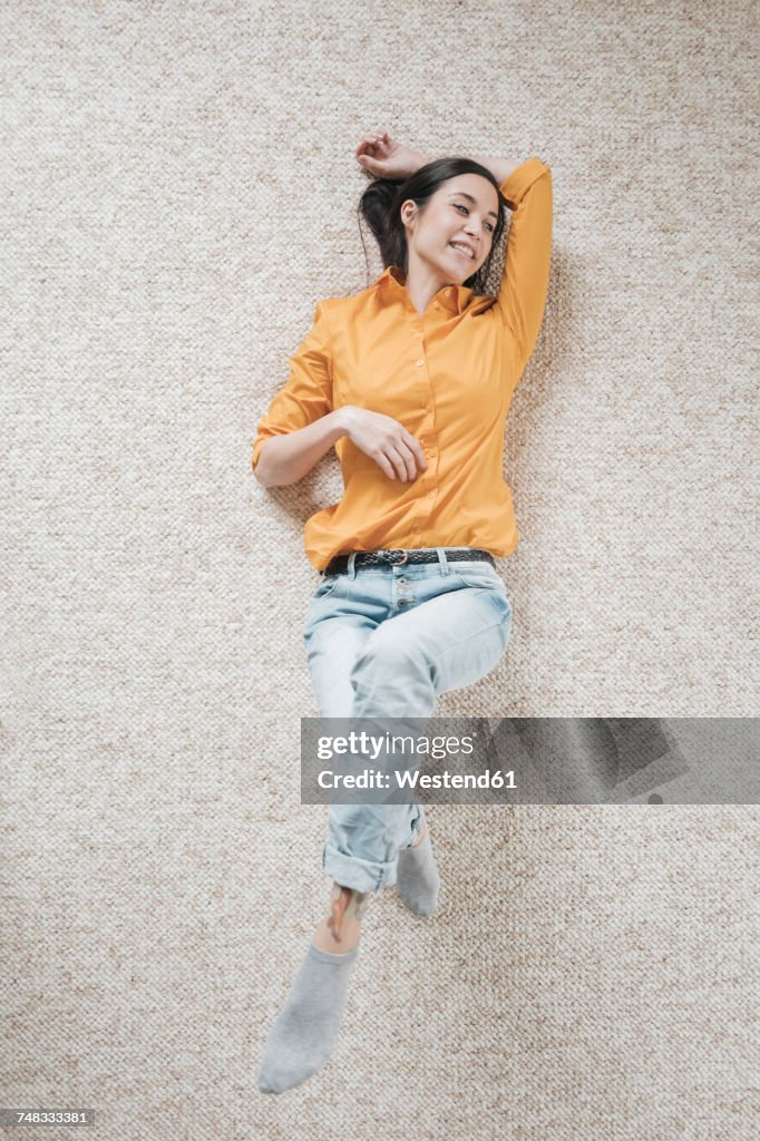 Young woman relaxing on carpet