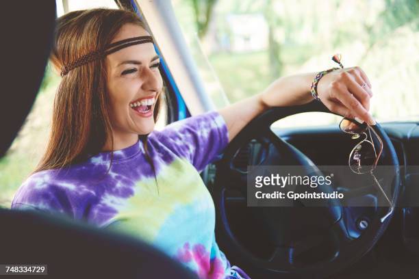 young boho woman laughing in front seat of recreational van - tie dye stock pictures, royalty-free photos & images