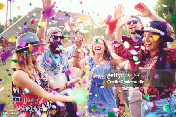 young adult friends throwing confetti at festival - multi colored blouse stock pictures, royalty-free photos & images