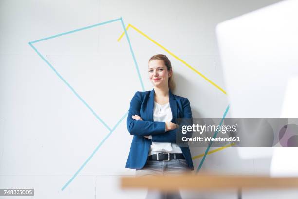 businesswoman standing in office with arms crossed - architectural designer stock pictures, royalty-free photos & images