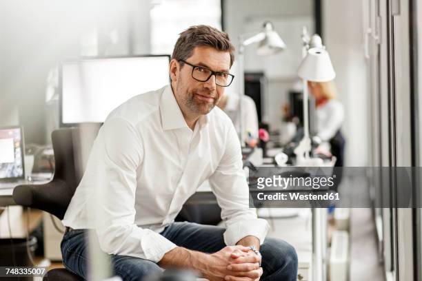 portrait of businessman at desk in office - casual businessman glasses white shirt stock pictures, royalty-free photos & images