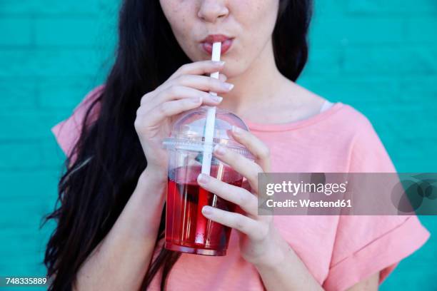 young woman drinking soft drink, partial view - erwachsene imitieren stock-fotos und bilder