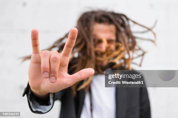 man showing rock and roll sign, close-up - hoorngebaar stockfoto's en -beelden