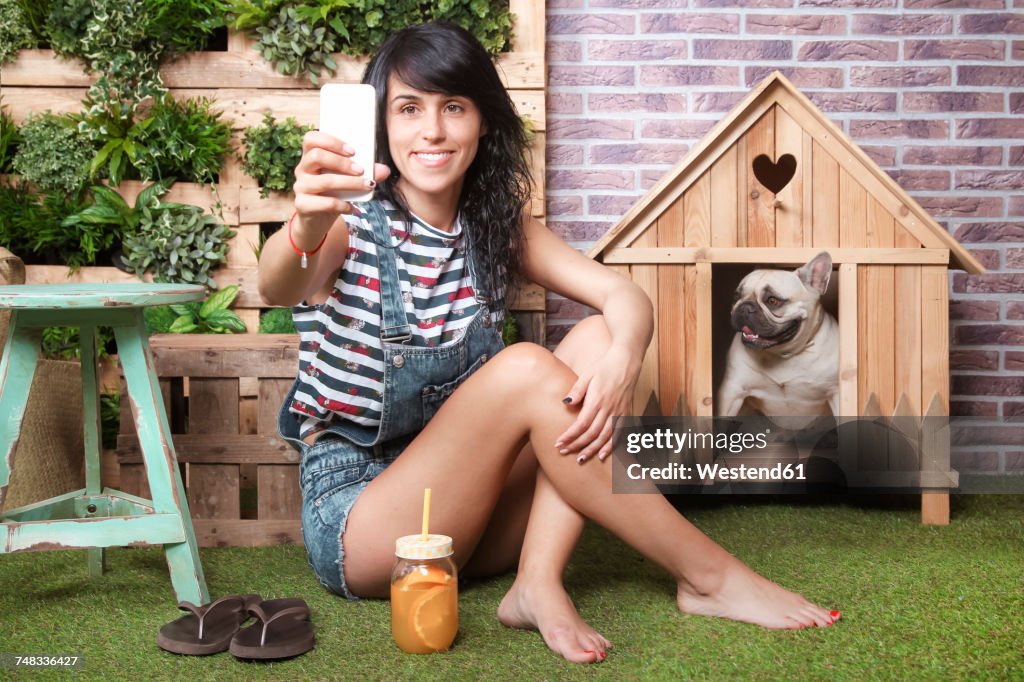 Woman and french bulldog taking a selfie on the terrace