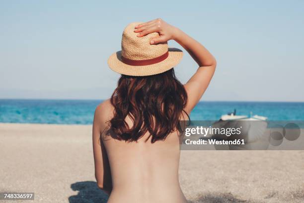 greece, young woman on the beach looking at the sea - halbbekleidet stock-fotos und bilder