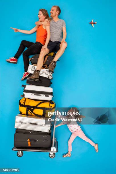 girl pushing luggage trolley with parents sitting on top - man pushing cart fun play stock pictures, royalty-free photos & images