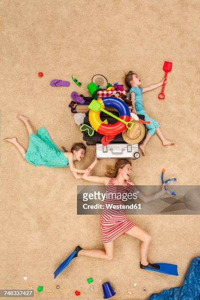 mother and daughters running to the sea, carrying beach equipment on the head - suitcase from above stock pictures, royalty-free photos & images