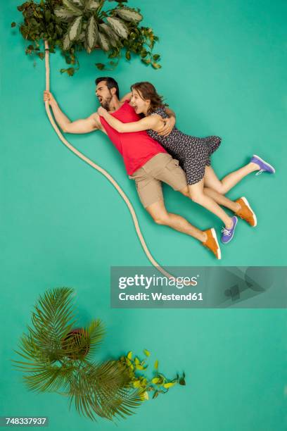 couple swinging on a liana through the jungle - liana stock pictures, royalty-free photos & images