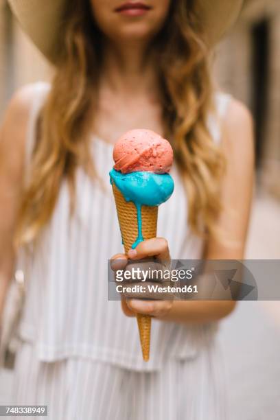 woman holding melting ice cream cone - frau eistüte stock-fotos und bilder