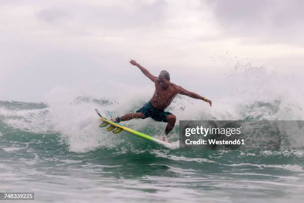 surfer on a wave - surfers in the sea at sunset stock pictures, royalty-free photos & images