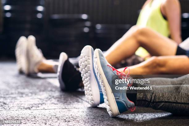feet of athletes sitting on floor in gym - youth sports training stock pictures, royalty-free photos & images