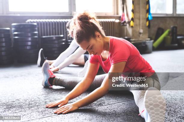 two young people stretching in gym - boys gymnastics stock pictures, royalty-free photos & images