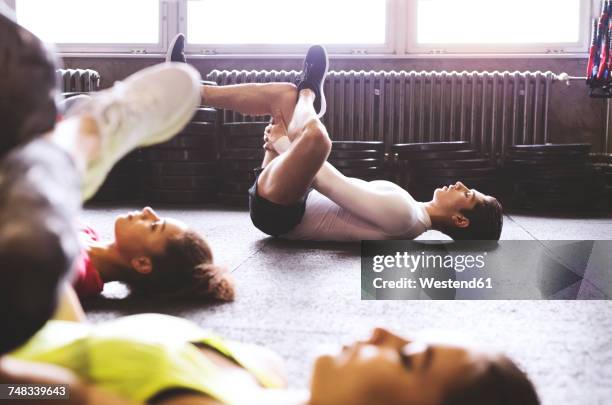 three young people exercising in gym - allongé sur le dos photos et images de collection