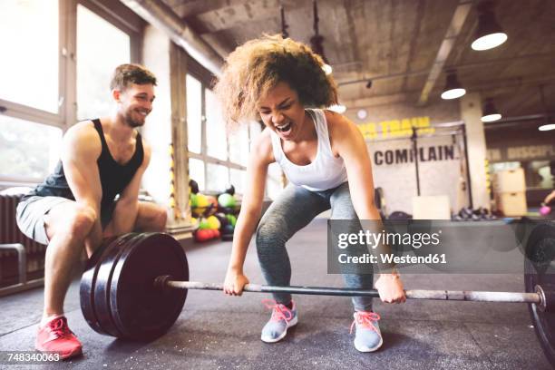 young woman with training partner preparing to lift barbell in gym - weightlifting imagens e fotografias de stock