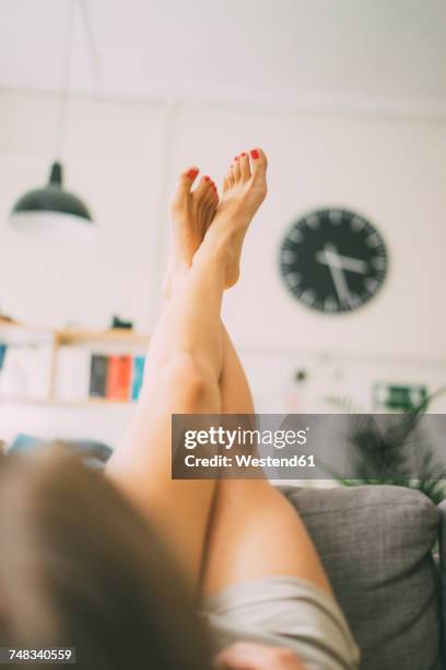 legs of woman lying on couch at home - de pé para cima - fotografias e filmes do acervo