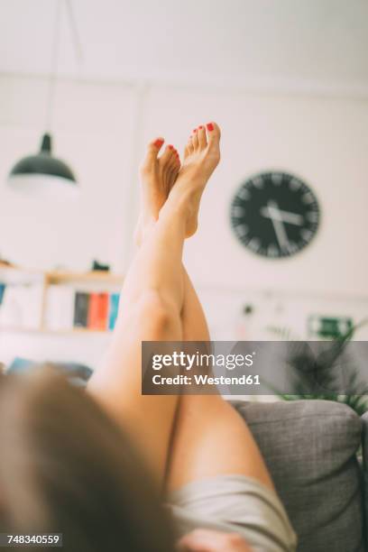 legs of woman lying on couch at home - feet on table bildbanksfoton och bilder