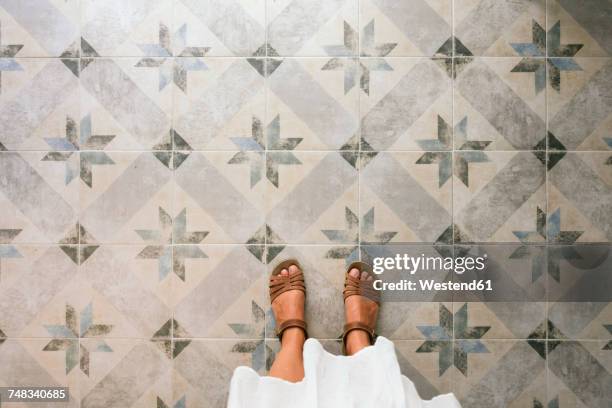 woman standing on ornate tiled floor - sandale stock-fotos und bilder