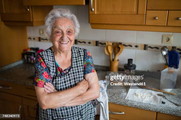 portrait of happy senior woman in the kitchen - happy old women stockfoto's en -beelden