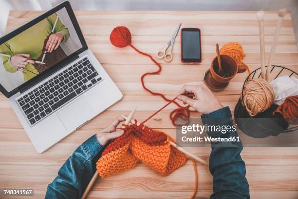 knitting man using laptop for watching online tutorial, partial view - tutorial stockfoto's en -beelden