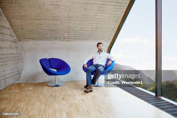 businessman sitting on chair in attic office - man front view stock pictures, royalty-free photos & images